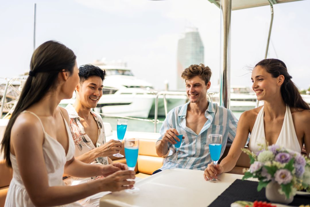 what to expect from yacht crew, a group of friends drinking champagne on a yacht