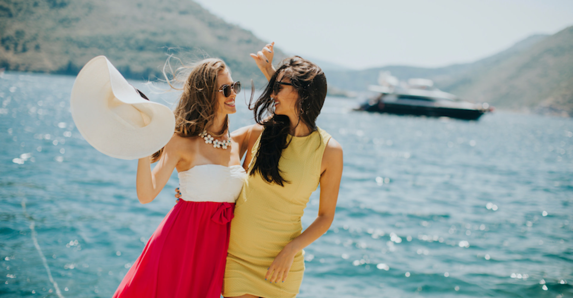 Multi-day yachts vs day yachts, two women near a yacht at sea.