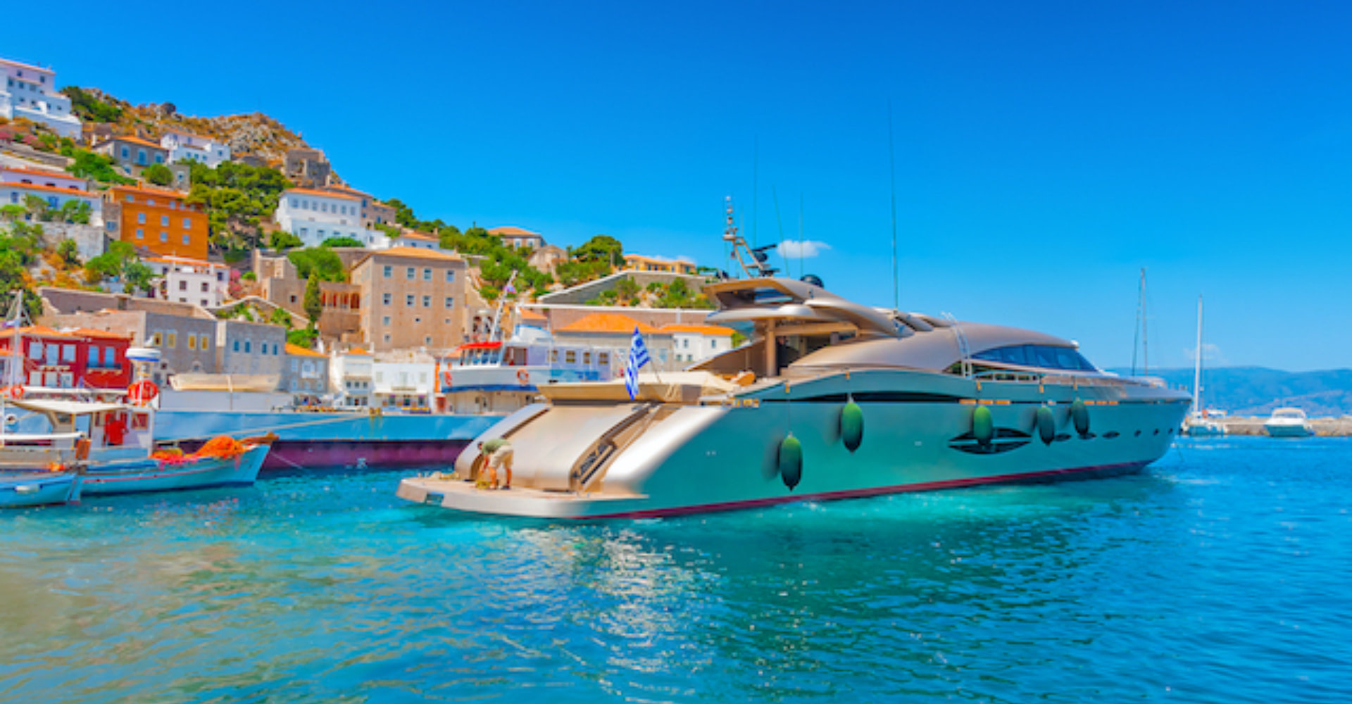 Yacht charter flexibility, yacht docked at a colourful Greek island.