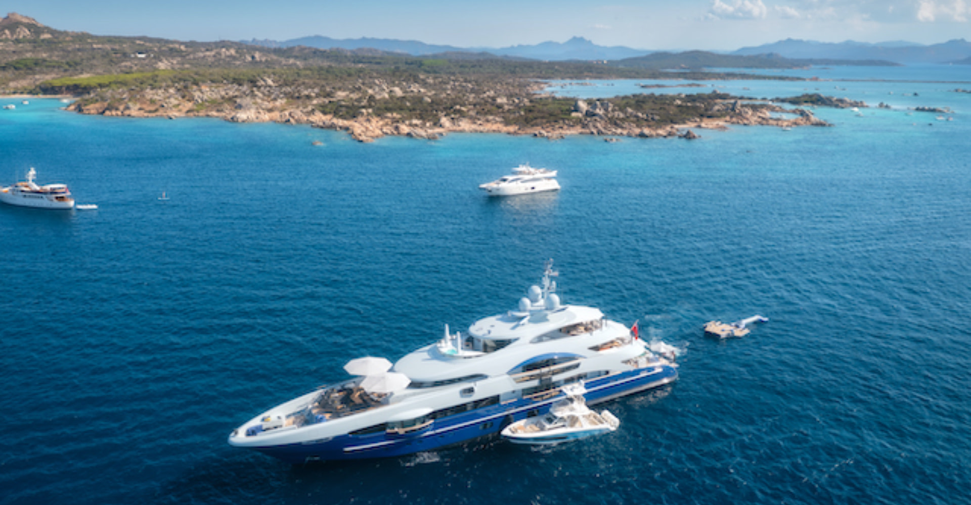 Buying your first yacht, woman on a beach watching yacht at sea.